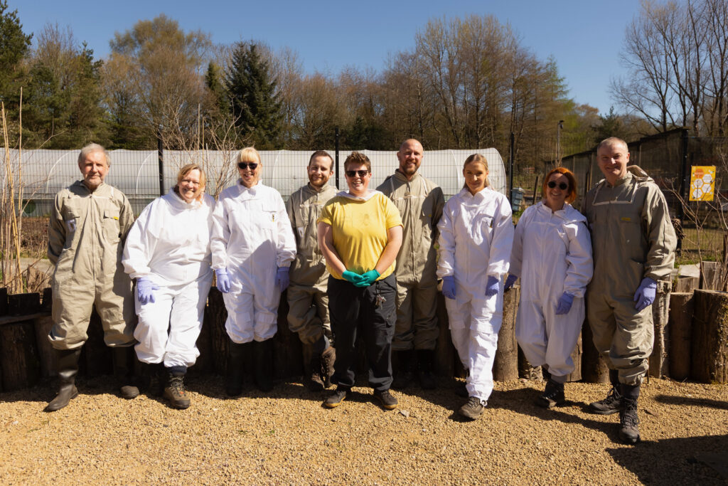 Damson and the Hive5 group attendants pose in a group in their bee suits.